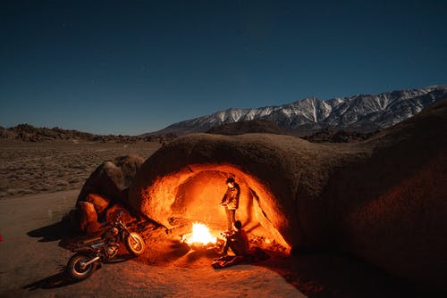 黑夹克的人在夜间坐在棕色沙子上 · 免费素材图片