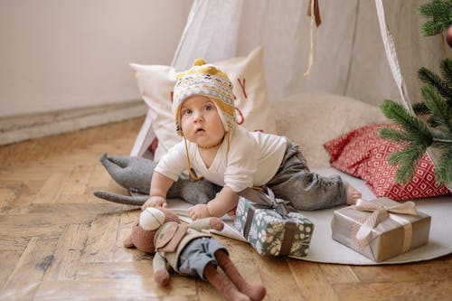 有关（頂部有小羊毛球的）羊毛帽子, 坐, 室內的免费素材图片