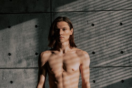 裸照的女人站在灰色的墙上 · 免费素材图片