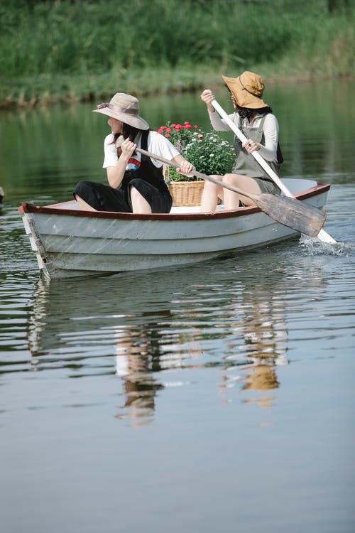 男人和女人骑着小船在水面上 · 免费素材图片