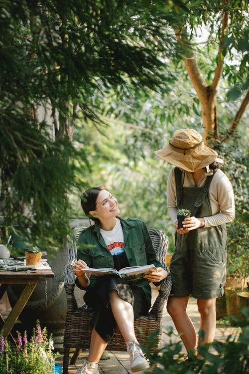 男人和女人坐在棕色的木凳上 · 免费素材图片
