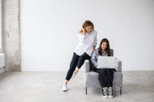 2名妇女坐在灰色的沙发上 · 免费素材图片