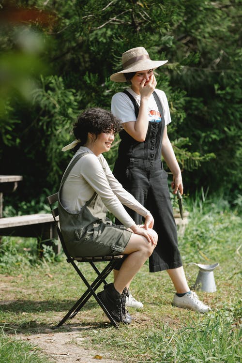 男人和女人坐在棕色的木凳上 · 免费素材图片