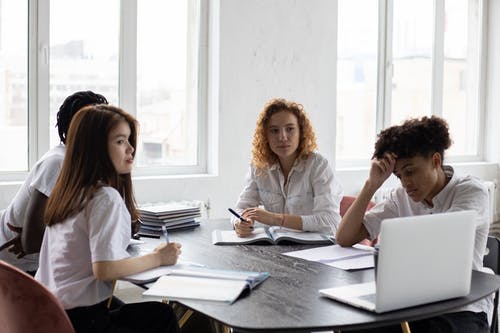 坐在白色礼服衬衫的女人旁边的白色礼服衬衫的女人 · 免费素材图片