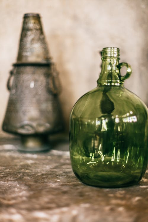棕色桌上的绿色玻璃瓶 · 免费素材图片