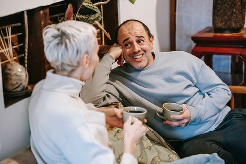 拿着白色智能手机的灰色毛衣的男人 · 免费素材图片