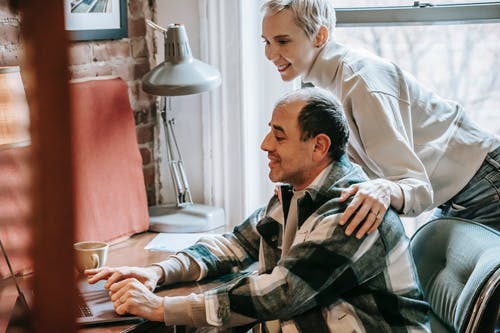 坐在白色礼服衬衫的男人旁边的黑色和白色格子礼服衬衫的男人 · 免费素材图片