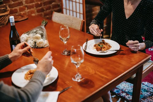 黑色的长袖衬衫，棕色的木桌上吃的女人 · 免费素材图片