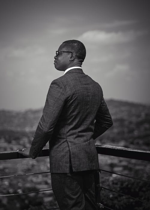 黑色西装站在木栅栏上的男人 · 免费素材图片