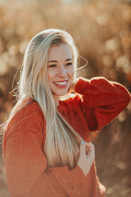 红色毛衣微笑的女人 · 免费素材图片