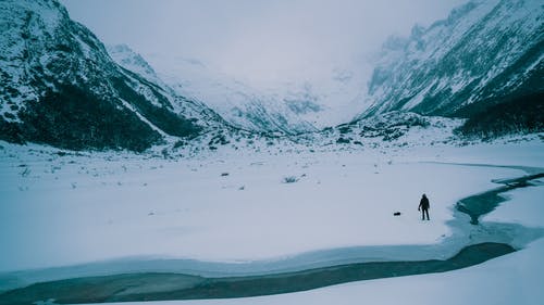 在积雪覆盖的田野上行走的人 · 免费素材图片