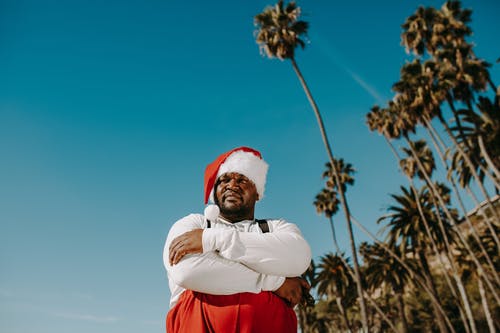 圣诞老人服装站在蓝天下的男人 · 免费素材图片