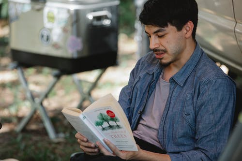 蓝色牛仔衬衫衬衫阅读书中的男人 · 免费素材图片