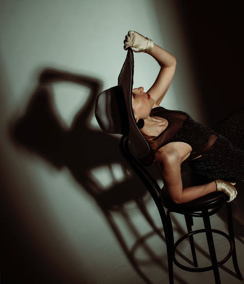 坐在椅子上的黑裙子的女人 · 免费素材图片