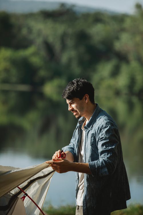 蓝色的衬衫和黑色皮夹克，拿着棕色的木棍的人 · 免费素材图片