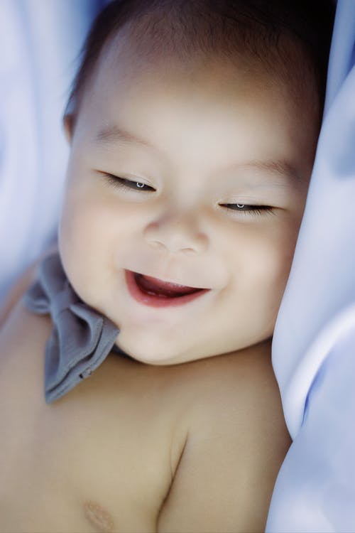 裸照婴儿躺在白色的纺织 · 免费素材图片
