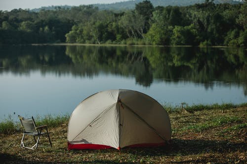 湖附近的绿色草地上的黄色圆顶帐篷 · 免费素材图片
