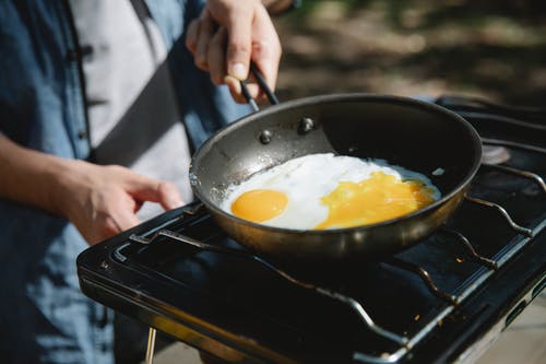 在黑锅上煮鸡蛋的人 · 免费素材图片