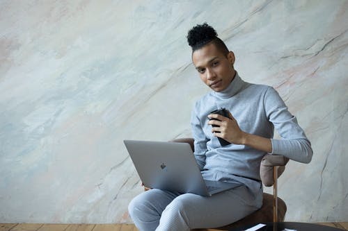 使用银色macbook的灰色长袖衬衫的男人 · 免费素材图片