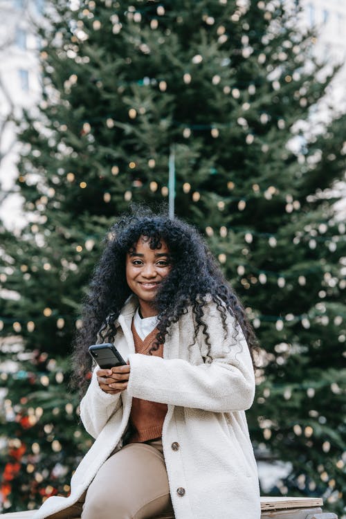 拿着黑色陶瓷杯的白大衣的女人 · 免费素材图片