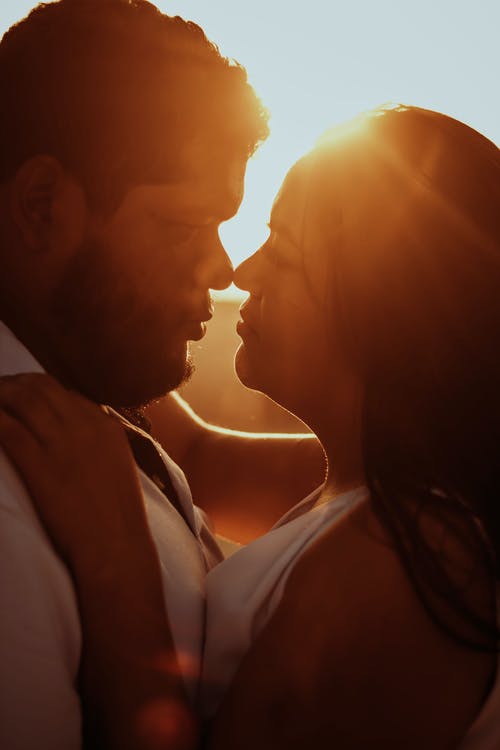 男人和女人在日落时接吻 · 免费素材图片