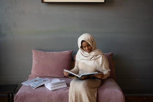 棕色的头巾，坐在紫色沙发上的女人 · 免费素材图片
