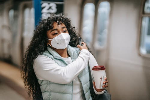 拿着红色和白色杯子的白色长袖衬衫的女人 · 免费素材图片