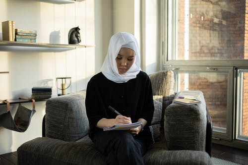 黑色的长袖衬衫，坐在灰色的沙发上的女人 · 免费素材图片