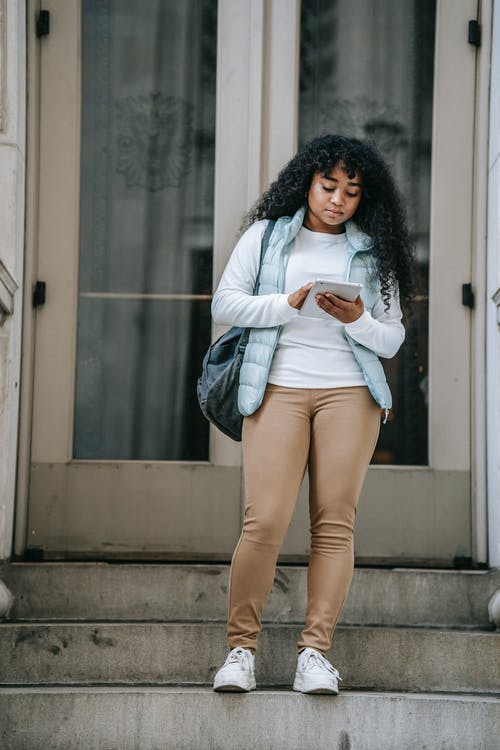 白色长袖衬衫和蓝色牛仔短裤，站在灰色的水泥地板上的女人 · 免费素材图片