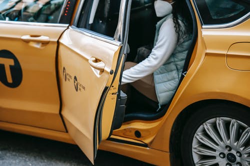 坐在黄色的车上的白色礼服衬衫和蓝色牛仔牛仔裤的男人 · 免费素材图片