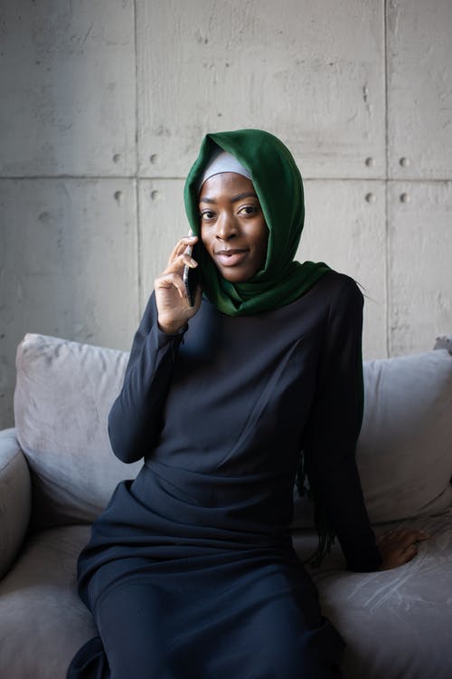 绿色的头巾和黑色的长袖衬衫，坐在沙发上的女人 · 免费素材图片