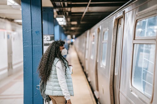 站在蓝色火车旁边的白夹克的女人 · 免费素材图片