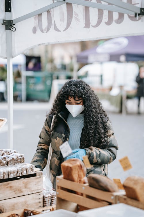 黑色和白色的围巾，拿着黑色的外套和黑色外套的女人 · 免费素材图片