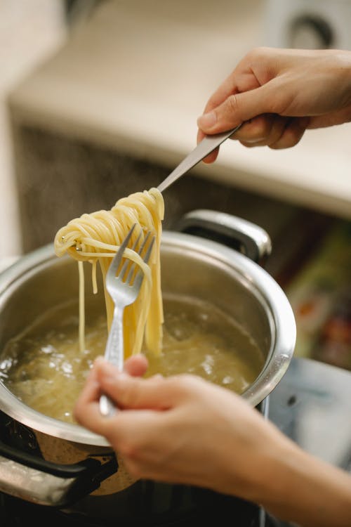 拿着黄色塑料勺子的人 · 免费素材图片