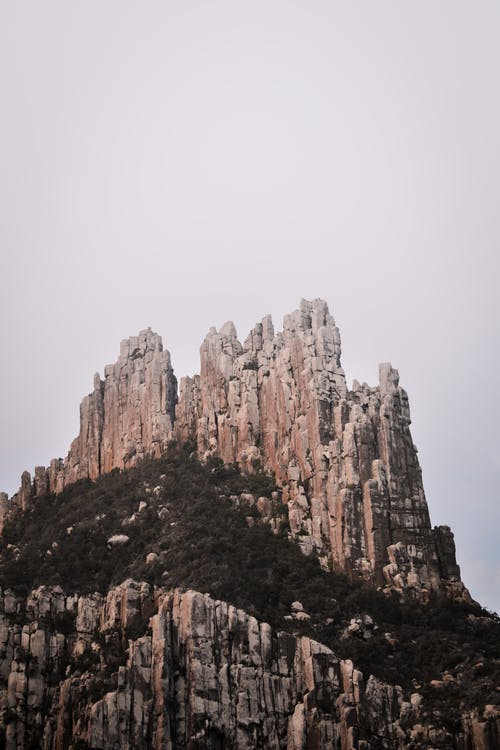 白色天空下的棕色岩层 · 免费素材图片