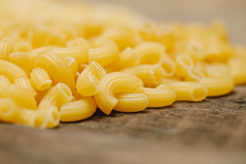灰色的木桌上的黄色面食 · 免费素材图片