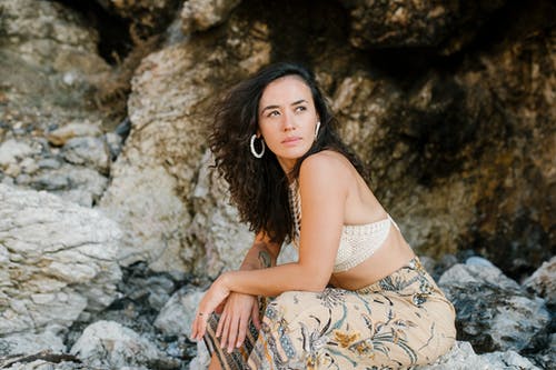 白色和棕色的花裙子，坐在岩石上的女人 · 免费素材图片