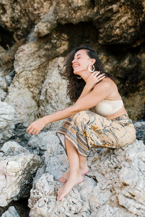 白色和棕色的格子衣服，坐在岩石上的女人 · 免费素材图片