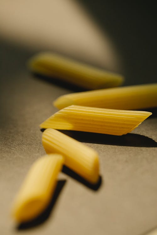 黑色桌子上的黄色面食 · 免费素材图片