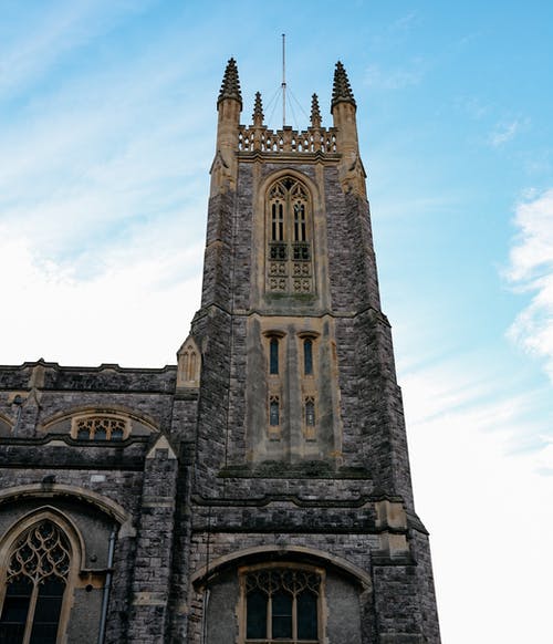 白云下的棕色混凝土教堂 · 免费素材图片