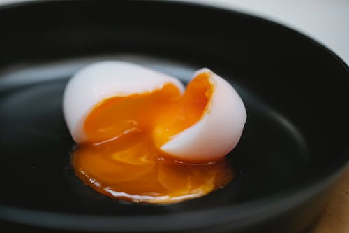 阳光明媚的一面鸡蛋在黑色印版上 · 免费素材图片