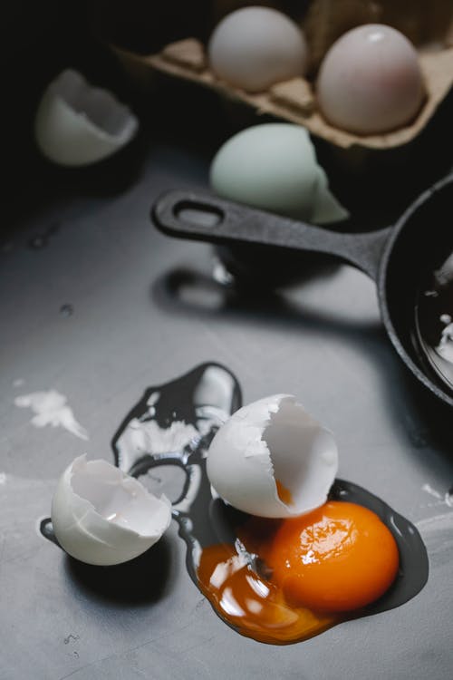 黑色煎锅上的白色和棕色鸡蛋 · 免费素材图片