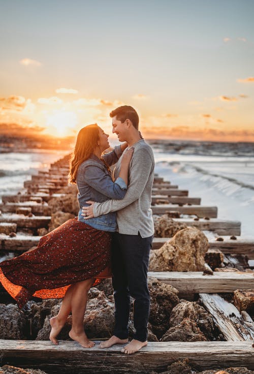 夫妇在日落时站在灰色的混凝土路面上 · 免费素材图片