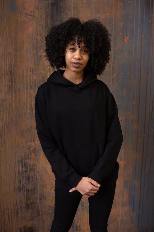 黑色拉链夹克站在棕色木墙旁边的女人 · 免费素材图片