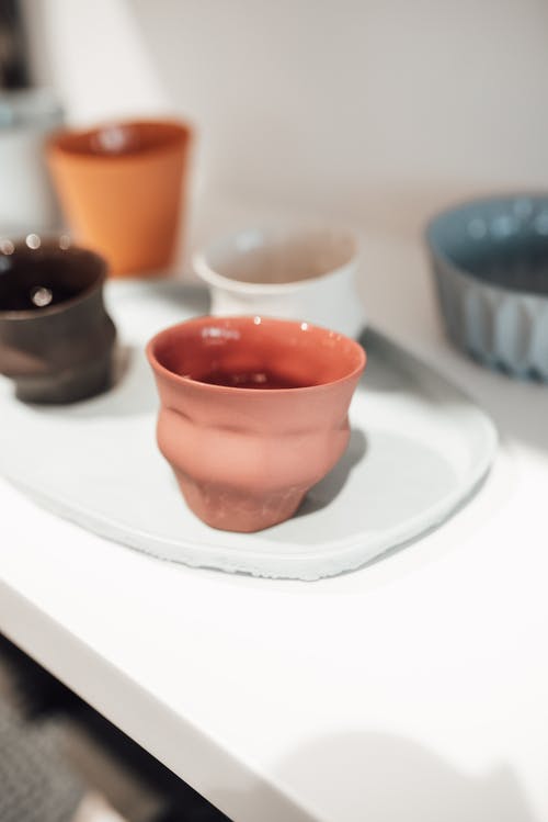 白色陶瓷板上的橙色陶瓷碗 · 免费素材图片