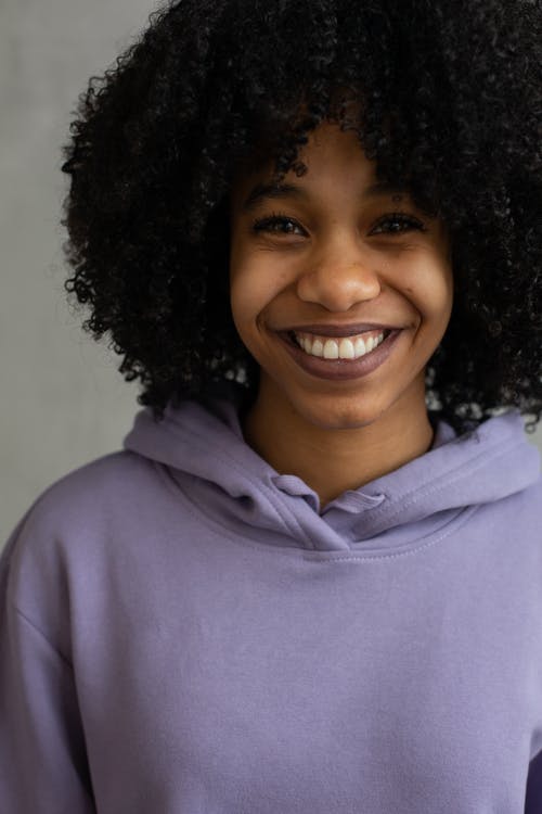 紫色连帽衫的微笑的女人 · 免费素材图片