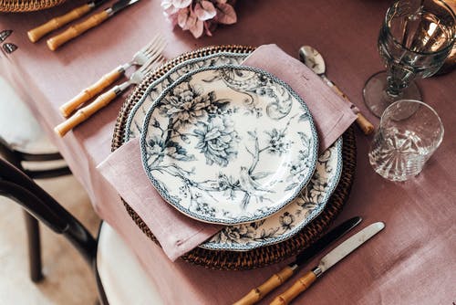 棕色木制的桌子上的白色和蓝色花卉陶瓷板 · 免费素材图片