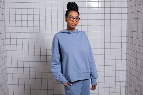 站在白墙旁边的蓝色毛衣的男人 · 免费素材图片