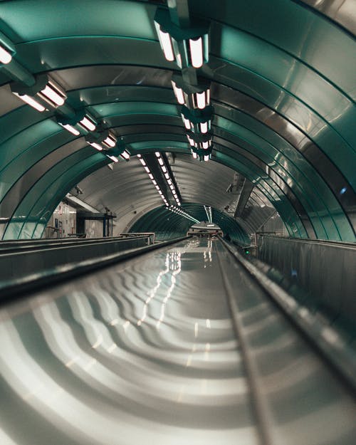 在灰色和白色的隧道上行走的人 · 免费素材图片