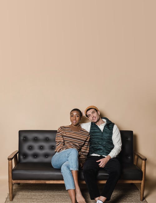 男人和女人坐在黑色的沙发上 · 免费素材图片